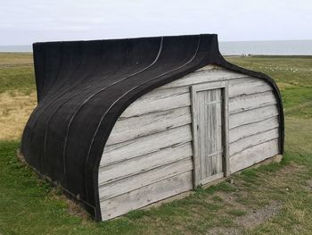 Built structure on field against sky