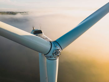 Close-up on the propellers of a wind turbine during a misty morning and sunrise. green energy. 