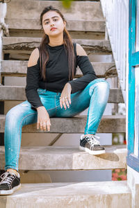 Portrait of young woman sitting on staircase