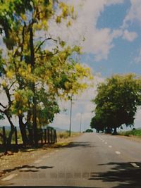 Road amidst trees against sky