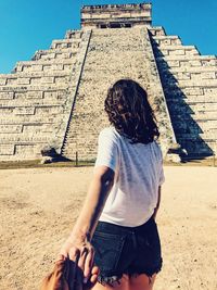 Low section of woman standing in front of a building