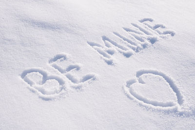 Text be mine and contour drawing in shape of heart on white snow