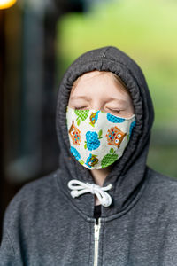 Young person wearing face mask with eyes closed during covid pandemic