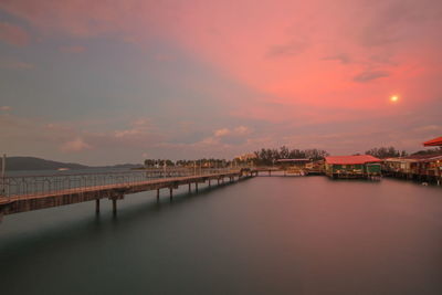 Bridge over river against sky during sunset