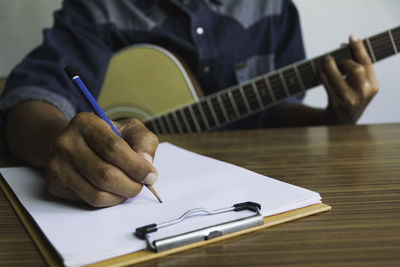 Close-up of man reading book on table