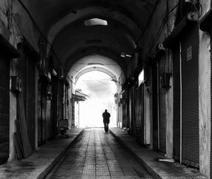 Rear view of silhouette man walking in corridor of building