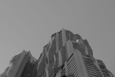 Low angle view of statue against building against clear sky