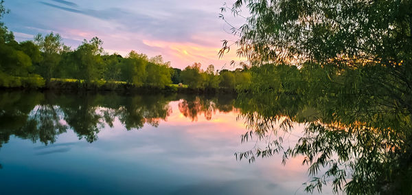 Scenic view of lake against sky at sunset