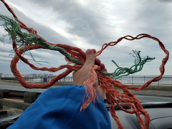 Close-up of rope tied hanging against sky