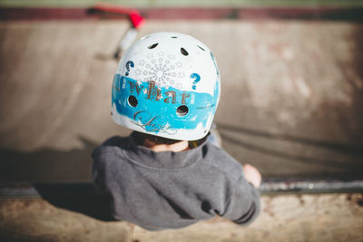 Rear view of boy wearing helmet at skateboard park