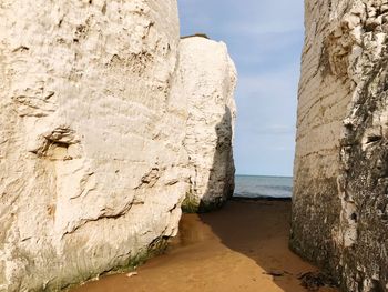 Rock formation on beach against sky