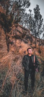 Full length portrait of young man standing in forest