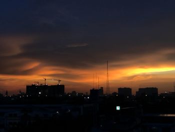 Silhouette buildings against sky at sunset