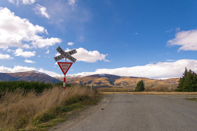 Road by mountains against sky