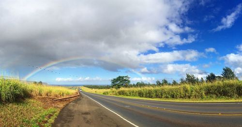 Country road against cloudy sky