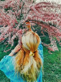 Rear view of woman with cherry blossom tree