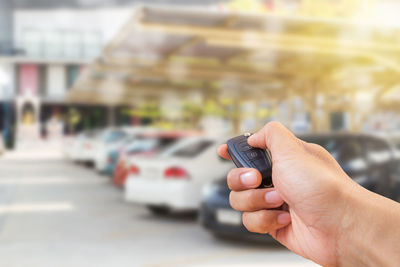 Midsection of person holding camera in city