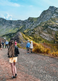 Rear view of people walking on road against sky