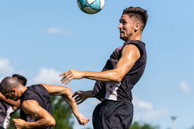 Low angle view of man playing with ball against sky