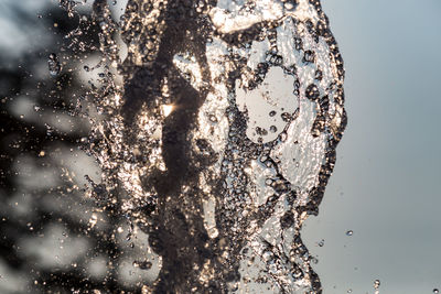 Close-up of bubbles in water against sky