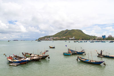 Boats moored on sea against sky