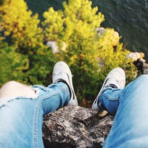 Low section of man relaxing on rock