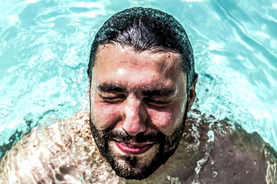 Close-up of smiling man swimming in pool
