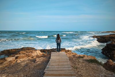 Rear view of man standing on beach