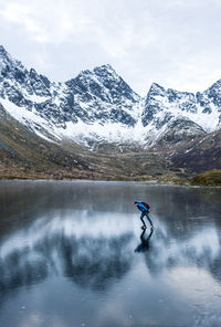 Man ice-skating on frozen lake