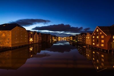 Reflection of illuminated buildings in lake at dusk