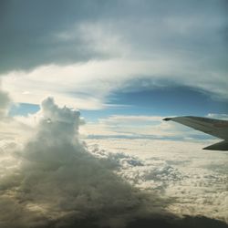 Cropped image of airplane flying over clouds