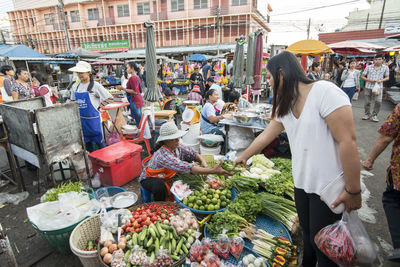 Woman buying vegetables in market