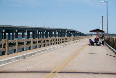 Man on bridge on road against sky