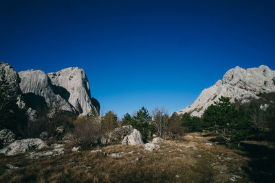 Low angle view of rocks against blue sky