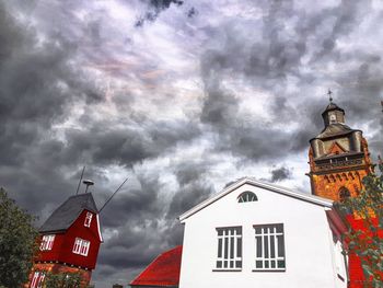 Low angle view of clock tower against dramatic sky