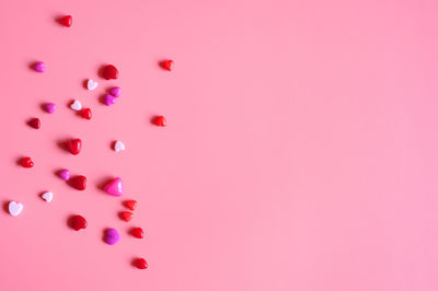 High angle view of multi colored candies against pink background