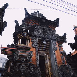 Low angle view of statues on building against sky