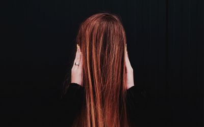 Woman standing against black background