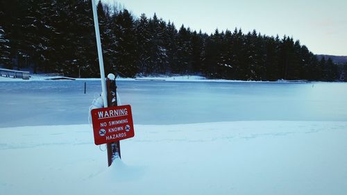 Information sign on snow against sky