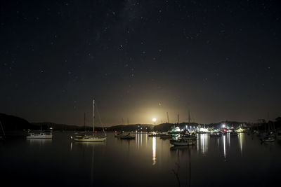 Boats moored in harbor at night