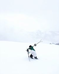 Rear view of man on snow covered mountain against sky