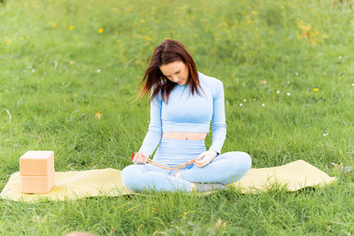 Full length of woman sitting on field