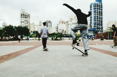 Full length of man skateboarding on city street
