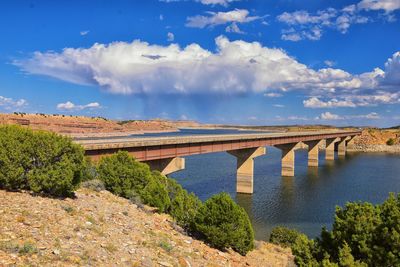 Arch bridge over river against sky