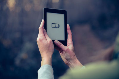 Close-up of hand holding mobile phone ebook