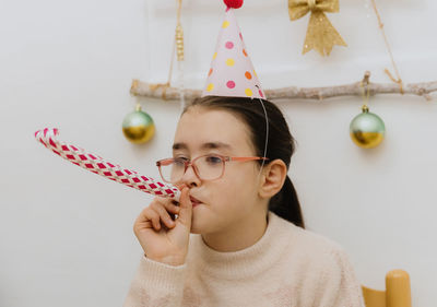 Portrait of a beautiful girl blowing a trumpet at a birthday party.