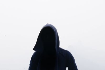 Person wearing hooded shirt against white background