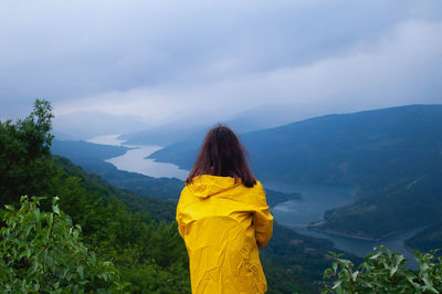 Rear view of woman standing on mountain