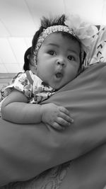 Close-up of cute baby on bed at home