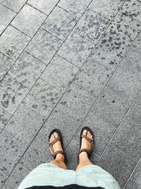 Low section of man standing on tiled floor